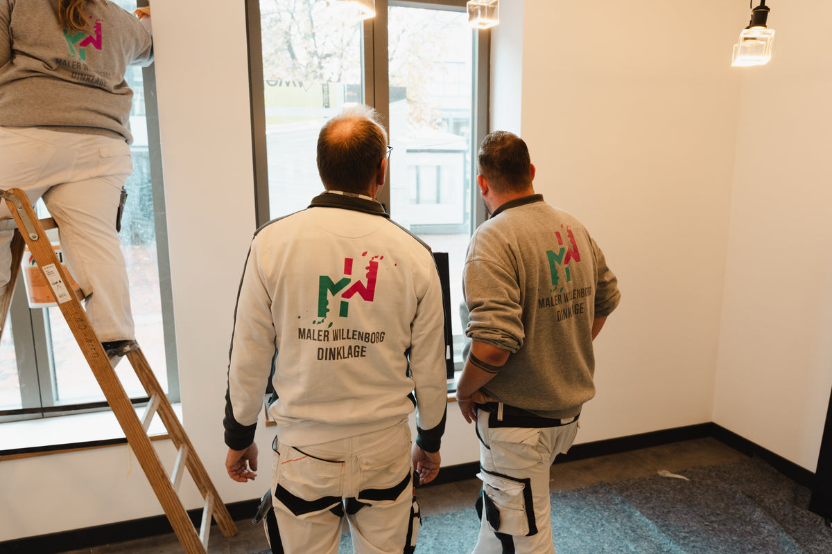 Zwei Maler von Maler Willenborg bei der Arbeit in einem hellen Neubau