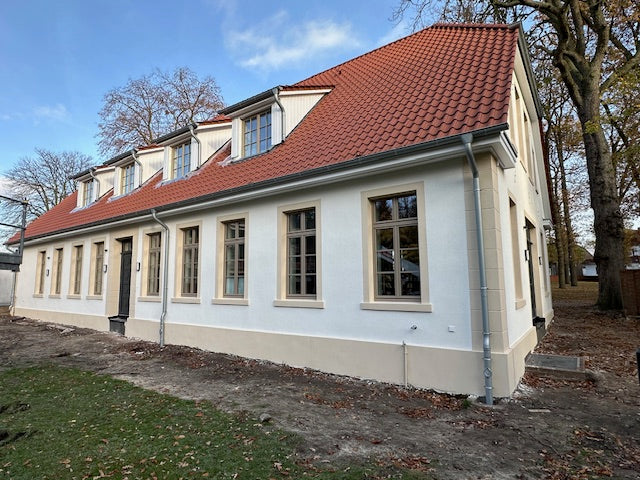 Gebäude mit frisch gestrichener weißer Fassade und rotem Dach